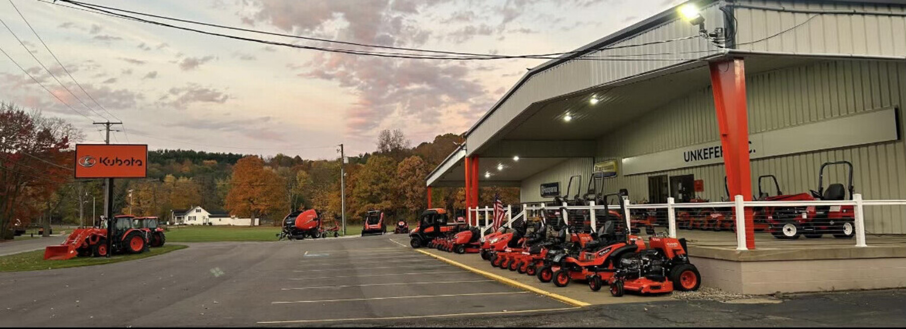 Unkefer Sales dealership at dusk, with Kubota equipment lined up out front