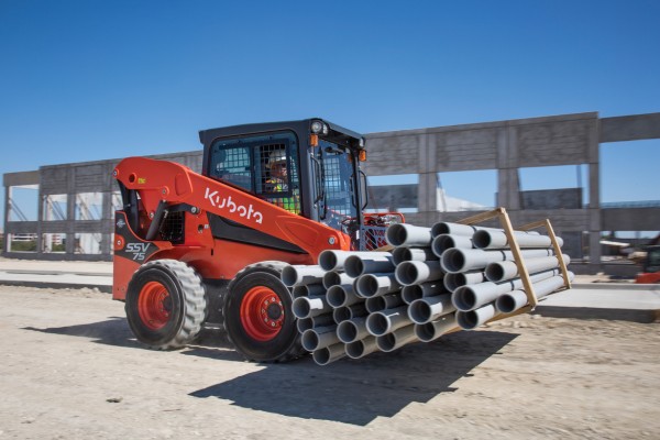 Kubota compact track loader parked on a gravel road at sunset