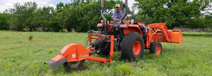 Kubota Standard L Series tractor pulling a box blade through a field