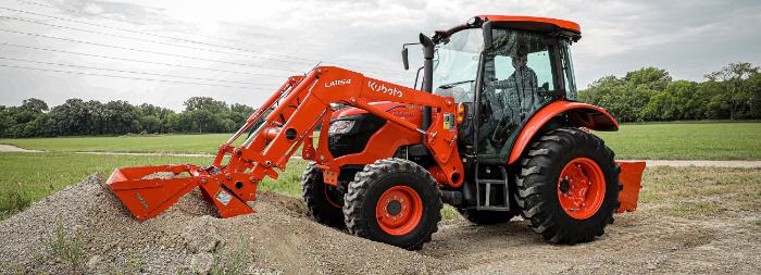 Kubota M4 Series cab tractor with a loader moving dirt