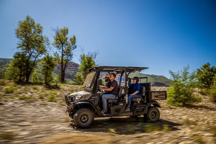 Kubota RTV-X Crew utility vehicle carrying passengers on a mountain trail