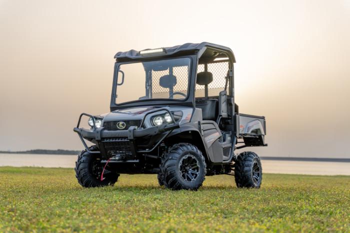 Kubota Sidekick gas utility vehicle parked in a field at sunset