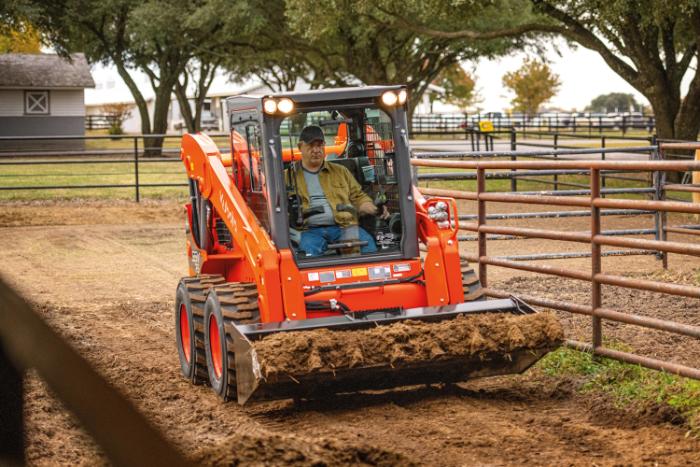 Kubota SSV Series skid steer loader working near a horse paddock