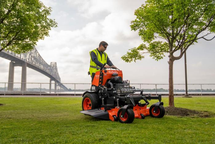 Kubota SZ Series stand-on mower cutting grass near a waterfront
